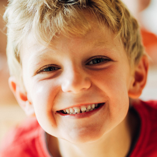 Die Alternative zu den Ganztagesangeboten der Grundschulen (Klasse 1 bis 4) ist der Schülerhort. Auf dem Bild ist ein Kind in rotem Shirt zu sehen das in die Kamera lächelt