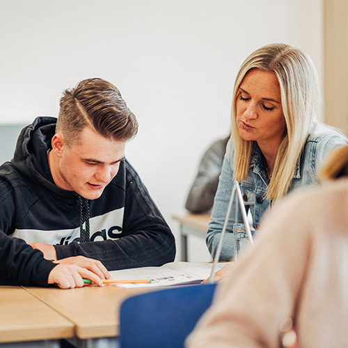 Für Schülerinnen und Schüler aus Ehingen und der näheren Umgebung, die eine weiterführende Schule ab Klasse 5 besuchen, bietet das Kolleg St. Josef mit dem Tagesheim ein besonderes Angebot. Das bild zeigt einen Schüler im Klassenraum zusammen mit der entsprechenden Lehrererin